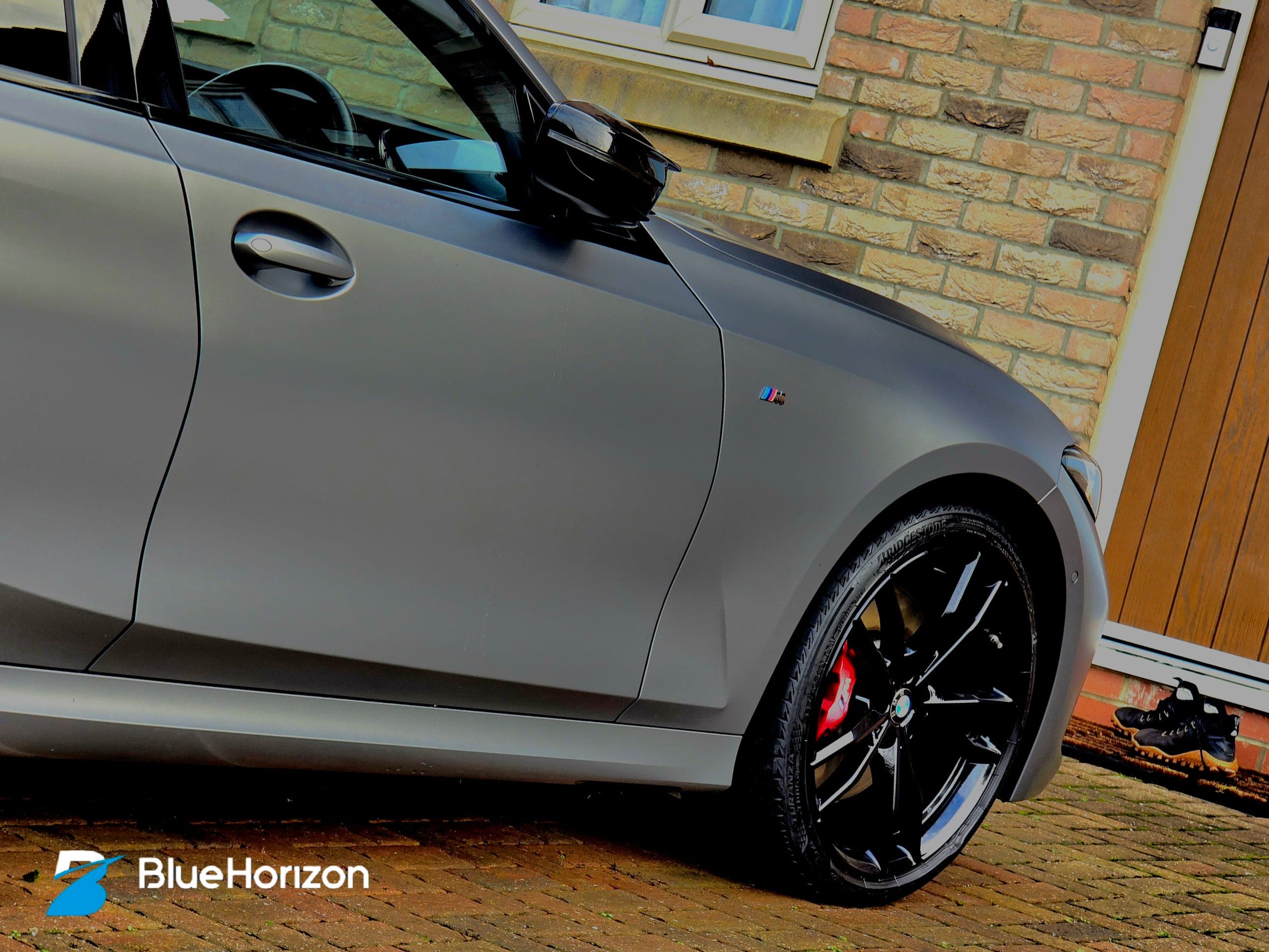 BMW M340i Touring front door showing M badge and red calipers — matte paint texture preserved with specialist products