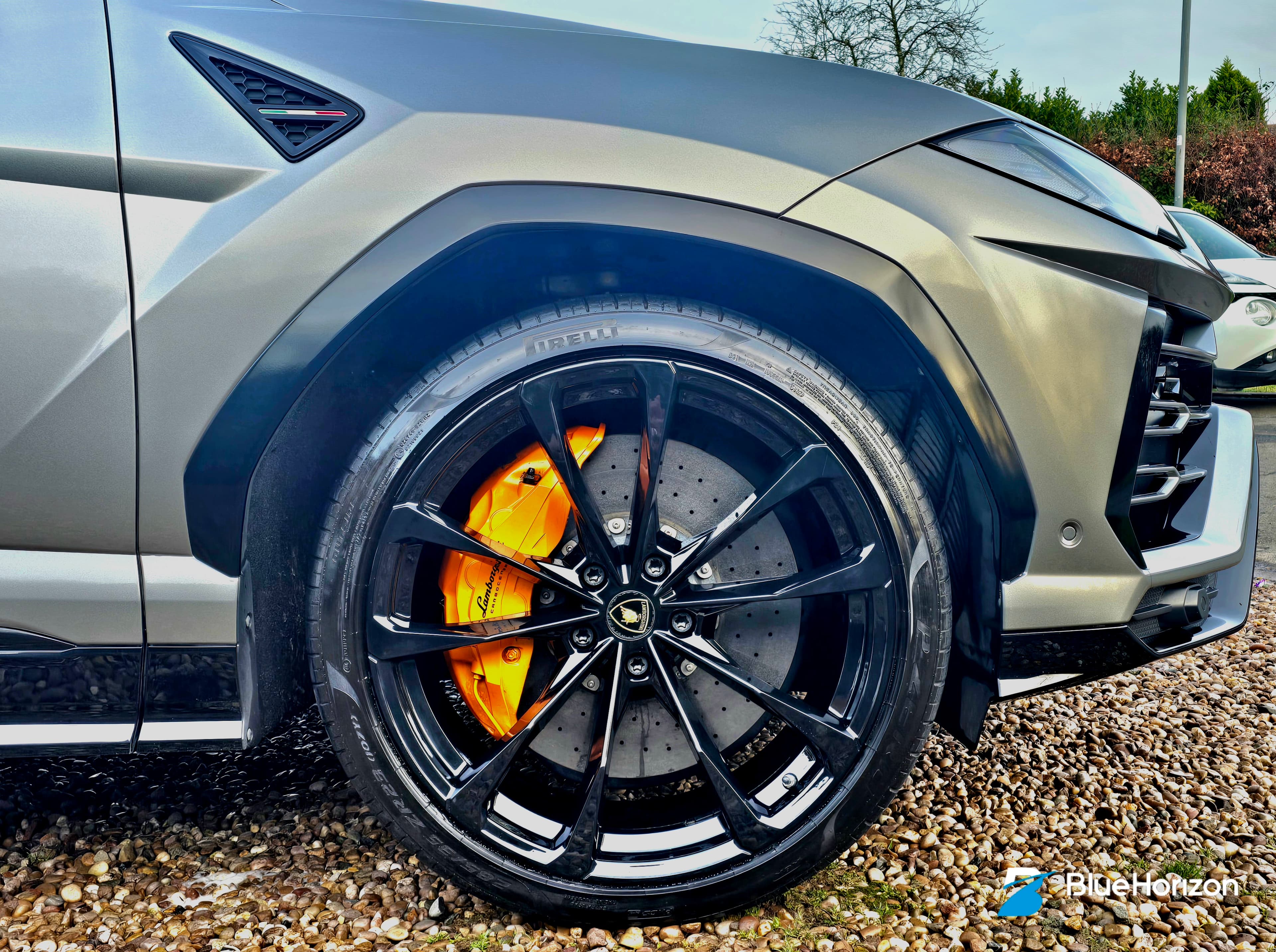 Lamborghini Urus alloy wheel detail with vibrant orange painted brake caliper and black multi-spoke alloy — Warwickshire